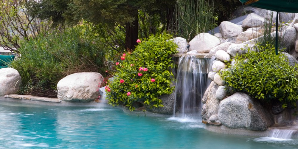 backyard waterfall over rocks with drop into pool
