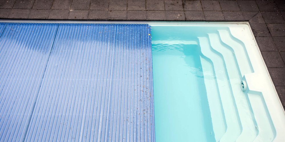 pool with blue plastic automatic pool cover closing