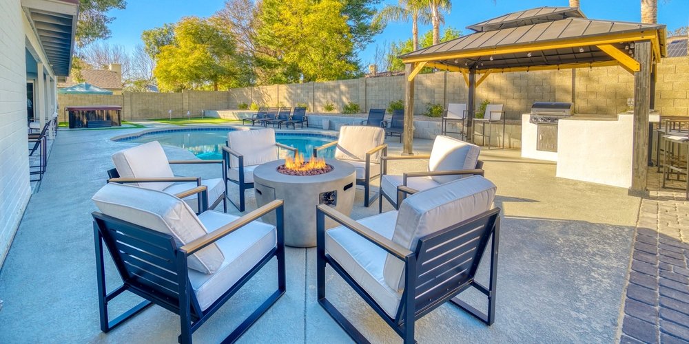 seats around a gas fire pit next to a pool