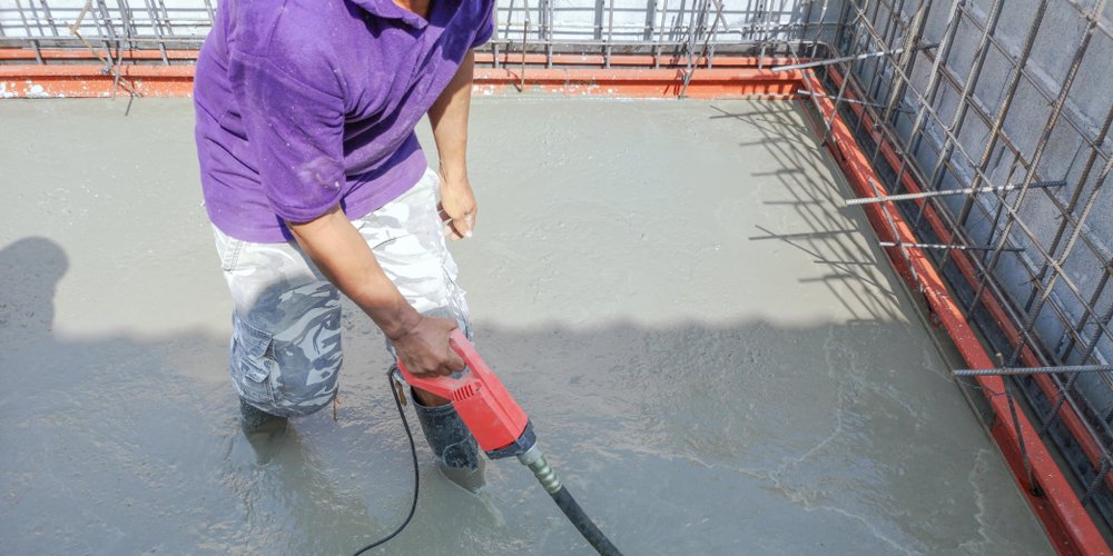 pool builder clears air bubbles from new concrete pool floor