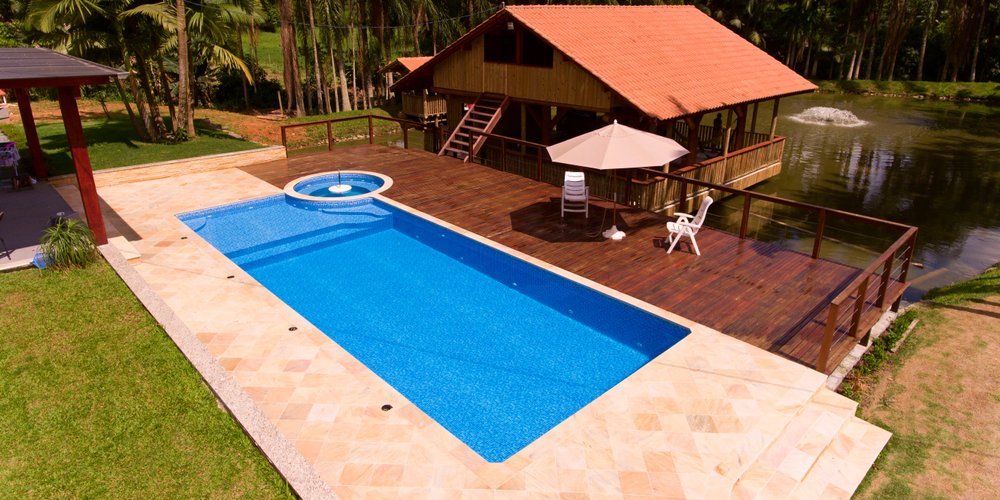 rectangle pool with deck next to a pond