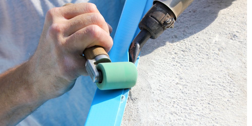close up of the edge of a pool liner being installed with a heat gun