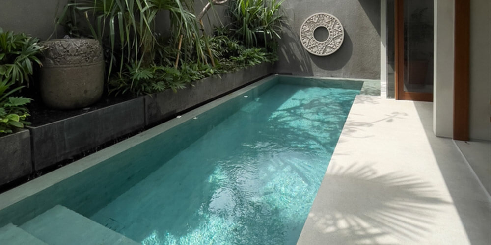 small rectangular pool right up to the property walls