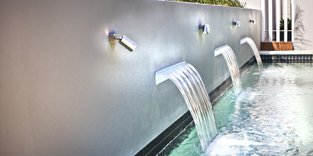 retaining wall with lights and a water feature mounted in it
