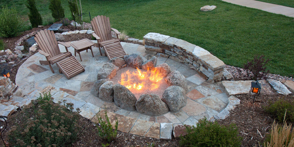 large stone firepit with outdoor chairs