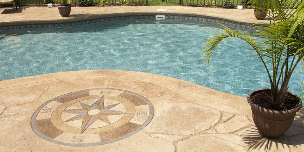 compass on stamped concrete next to a pool