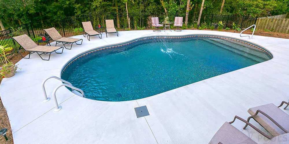 backyard pool with brushed concrete decking