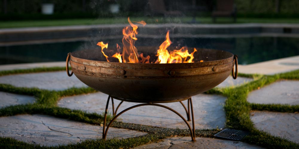 metal firepit in front of a pool