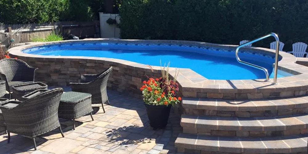 stone swimming pool with raised edges and seating next to the pool's wall