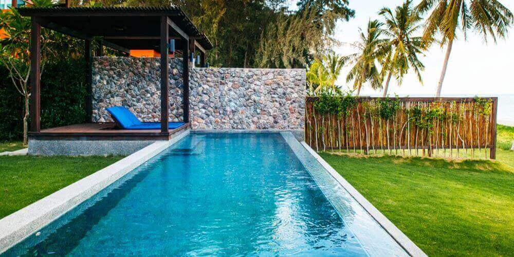 rectangular semi inground pool with a small deck and pergola 