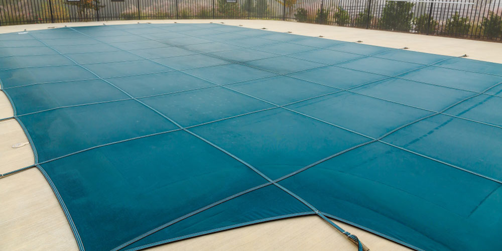 green mesh pool cover on a foggy day