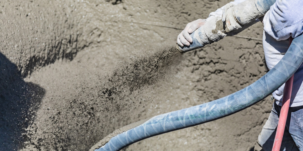 A person pouring cement in a pool construction site