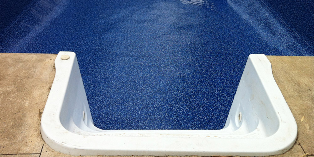 Steps of a blue tiled swimming pool. 
