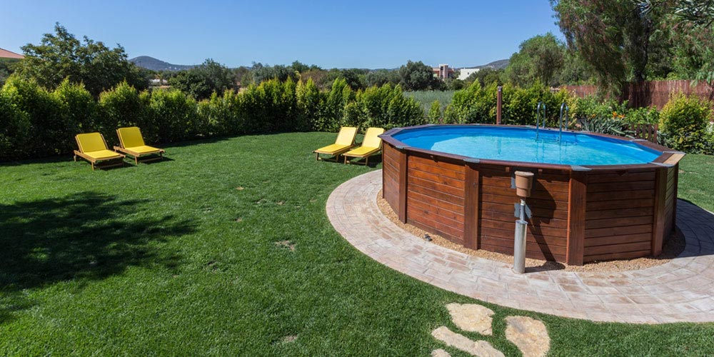 above ground pool set on a concrete pad in the backyard