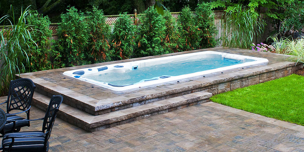 swim spa installed in the ground with tiles surrounding it