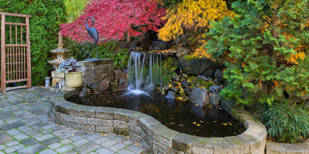 garden waterfall pond with brick paver stone hardscape