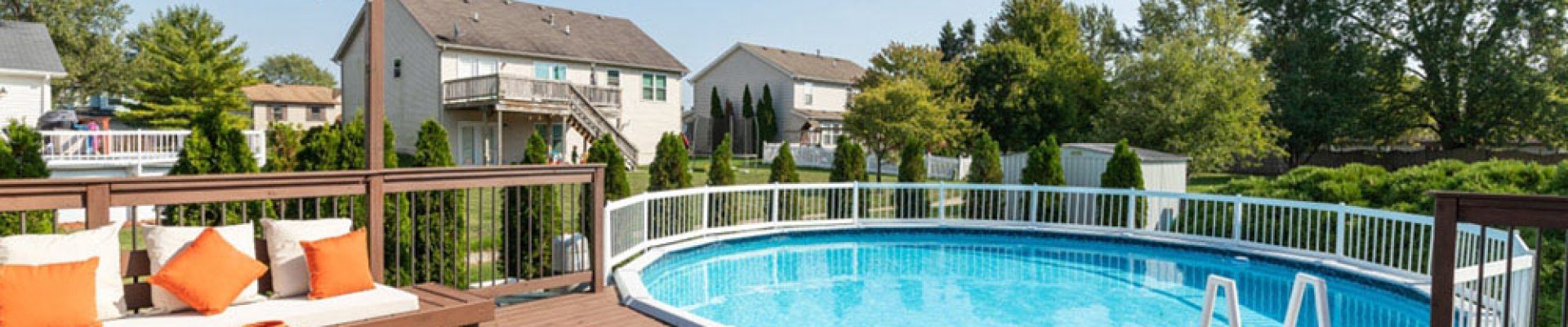 backyard deck with a pergola over some seating and a large above ground pool