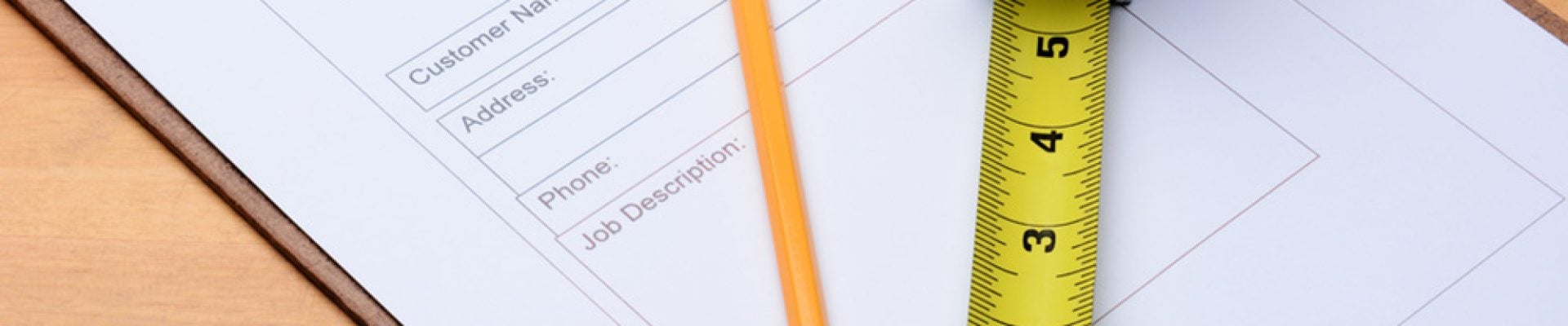 closeup of a Contractors estimate form with a pencil and tape measure